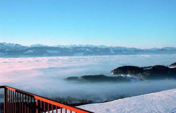 Ein Nebelmeer im Zürcher Oberland, dahinter die Alpenkette der Schweiz.
